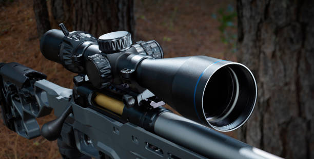 Rifle scope on a bolt action rifle in a forest
